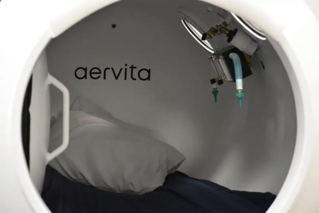Inside an Aervita hyperbaric oxygen chamber with pillow and oxygen mask ready